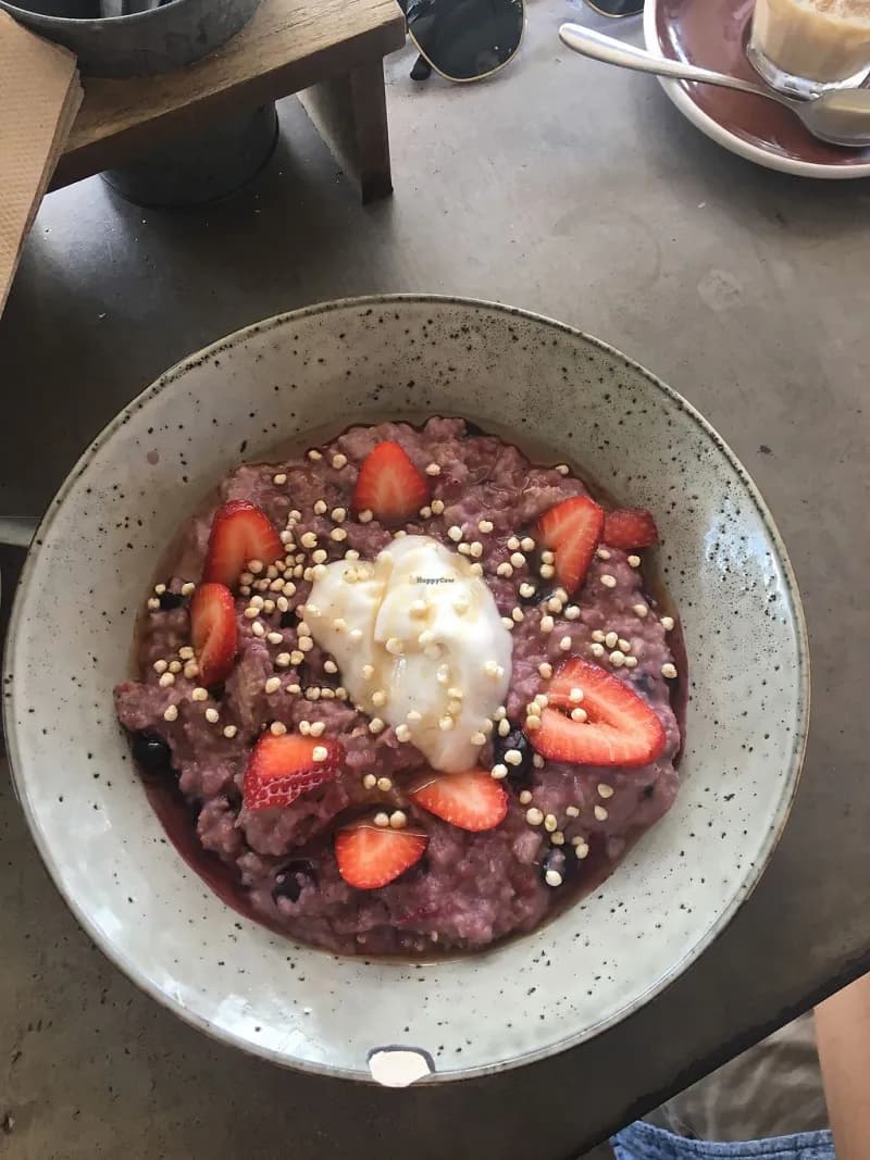 Berry porridge bowl with strawberries and house granola